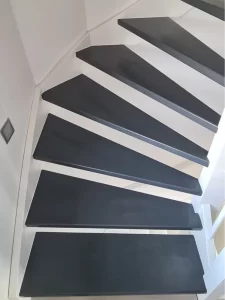 Renovated staircase with striking black and white steps, showcasing its paint upgrade