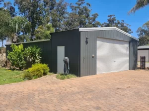 Renovated garage with brick driveway and wall, highlighting a fresh coat of paint.