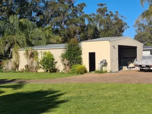 Plain garage facade before the paint job upgrade, seen in the yard of a house.