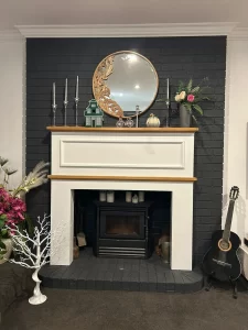 A stunning fireplace with a mirror and flowers on the mantle, transformed from dull to vibrant, ready to add warmth and become a captivating focal point.