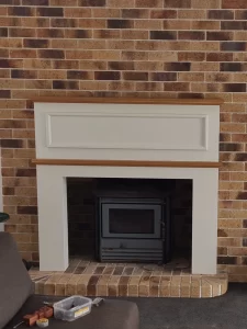 A brick fireplace in a living room, ready for a burst of colour and personality. Stay tuned for the stunning makeover!