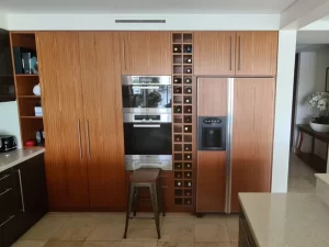 Brown-themed kitchen with wine rack and bar stool, captured before the paint job.